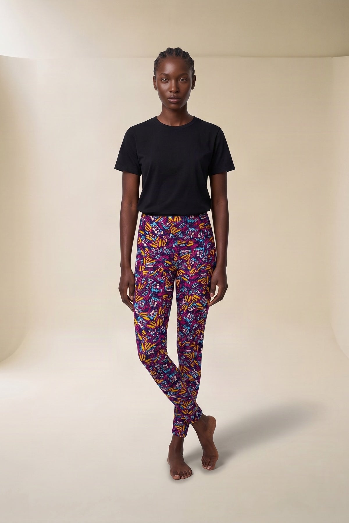 Front view of high-waisted leggings in a plum butterfly print with magenta, gold and blue wings, styled with a black tee
